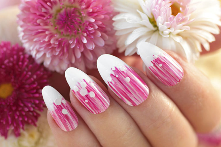 French oval manicure with a striped gradient in pink tones. Summer flower nail design close-up.